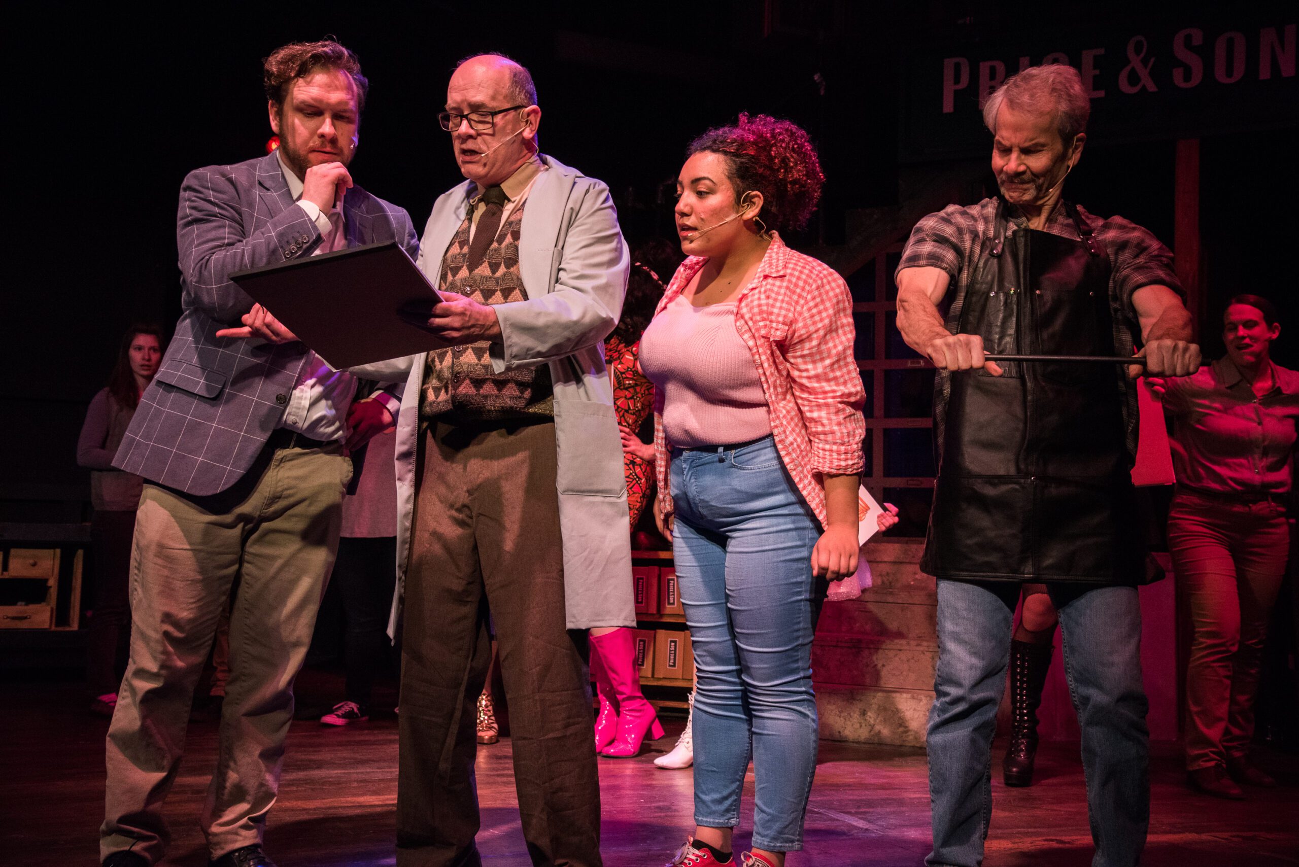 Actors gathered around looking at a drawing. Photo from KINKY BOOTS, Live Arts 2023/24 EXPECTATIONS Season. Photo by Will Kerner.